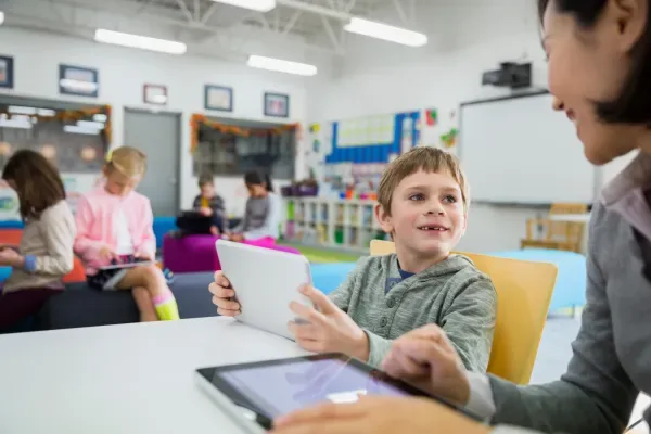 teacher-and-elementary-student-using-digital-table-2026-01-11-08-43-48-utc-69b7e549b395a