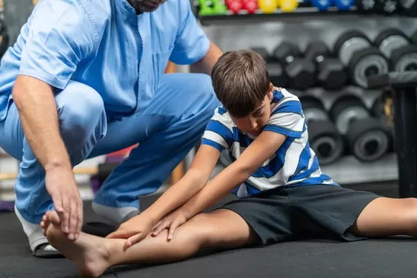 physical-therapist-instructing-a-young-boy-in-exer-2026-03-16-03-31-30-utc-69b7e58a8738f