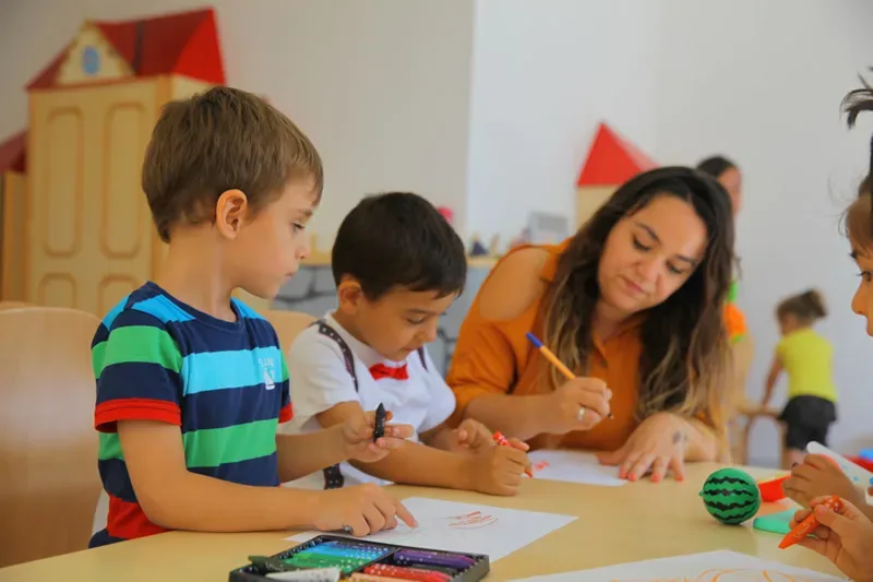 23 Nisan etkinliğinde öğretmen eşliğinde çalışan çocuklar