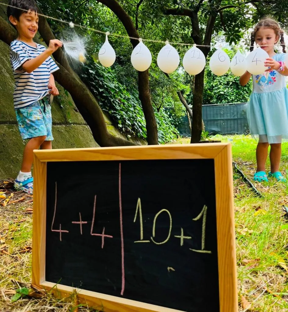 Beş yaş grubu çocuklar bahçede oyunla matematik — balonlarla sayı etkinliği